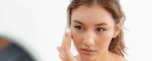 User examining skin for Sensitive Skin Triggers while looking in a mirror.