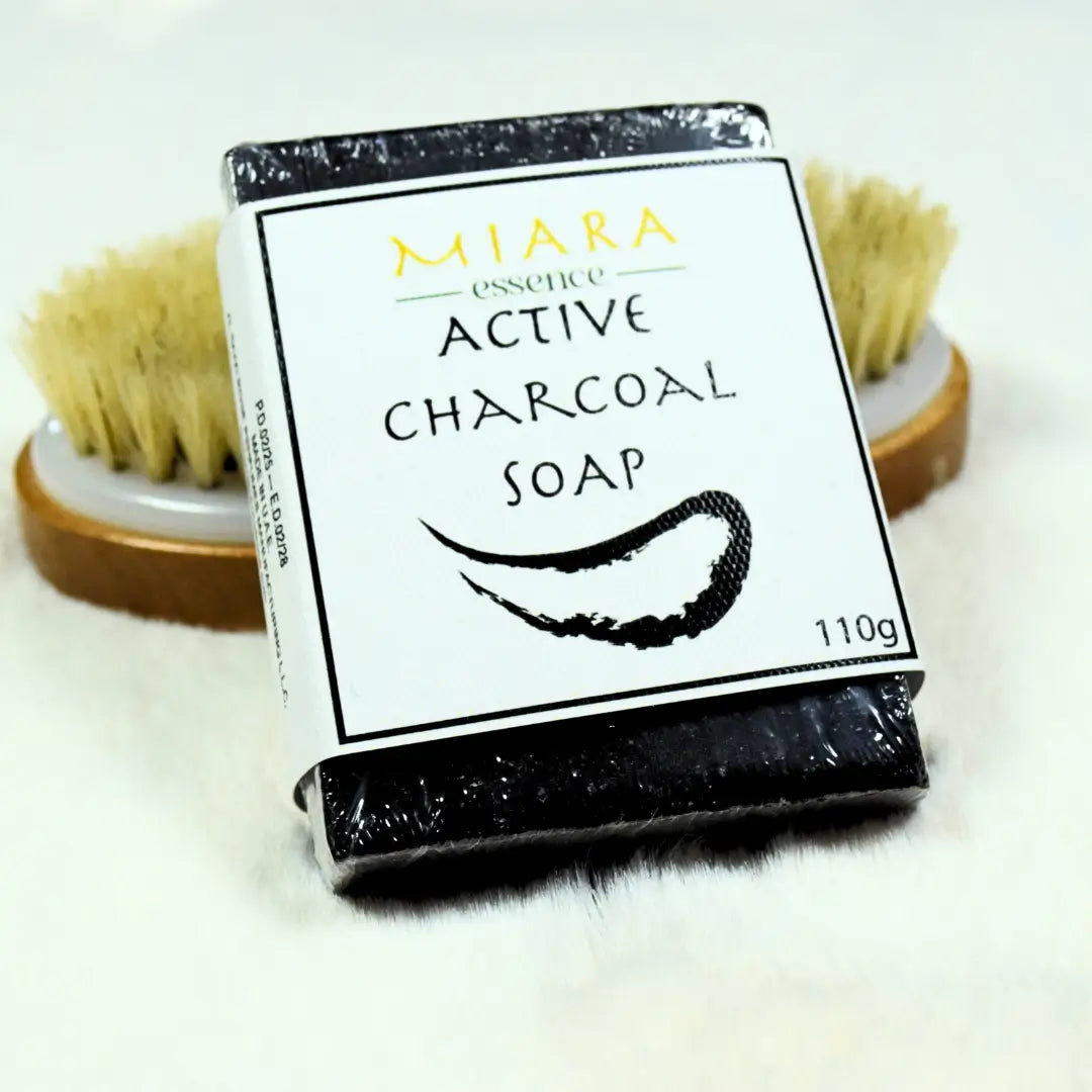 Bar of active charcoal soap activated charcoal soap with packaging and a brush in the background